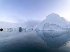Arctic icebergs in the Arctic sea of Greenland. You can easily see the iceberg above and below the water. Sometimes it is hard to believe that 90 percent of an iceberg is under water