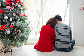 几个坐在圣诞树旁图片