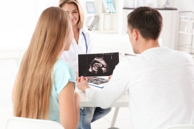 婦科會(huì)診。醫(yī)生顯示超聲掃描嬰兒對(duì)夫婦