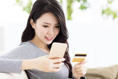 年輕漂亮的女人，與信用卡和智能手機(jī)