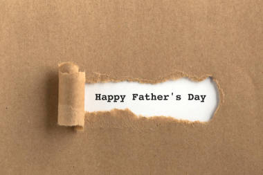 撕裂的棕色紙后面的文本