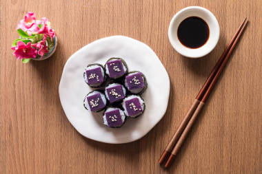 Sushi - Purple sweet potato on sushi rice white ceramic plate. The purple-heart sweet potato benefits from high beta-carotene and cooking carbohydrates. Top view