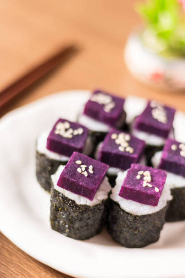Sushi - Purple sweet potato on sushi rice white ceramic plate. The purple-heart sweet potato benefits from high beta-carotene and cooking carbohydrates. Shut down