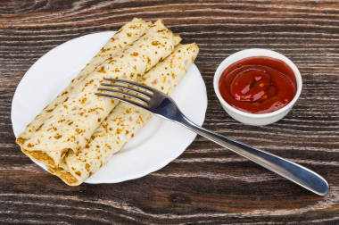 煮熟的煎饼塞在板、 番茄酱和叉