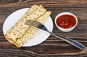 煮熟的煎饼塞在板、 番茄酱和叉