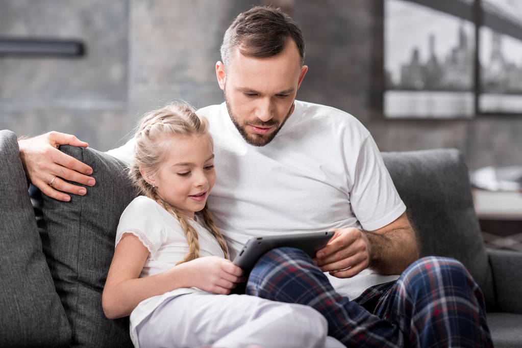 父亲和女儿使用数字平板电脑照片