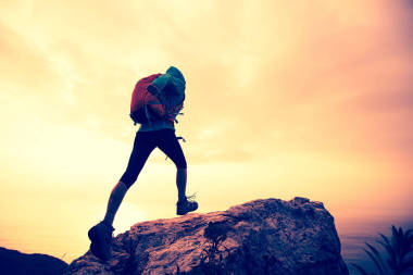 攀上山峰的徒步旅行者圖片