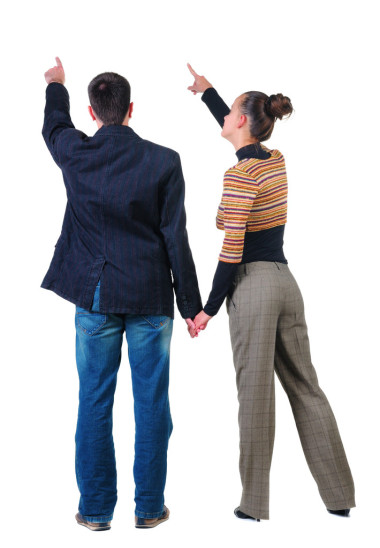 后指着墙上的年轻夫妇观.图片