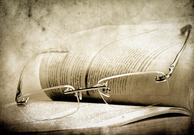 已打开的书页和背景下复古眼镜的特写