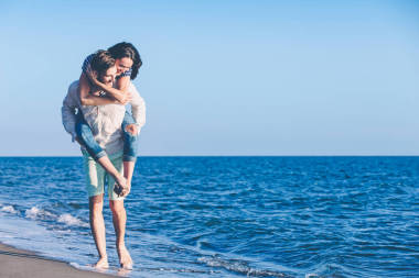 男人在海灘的女朋友給小豬回