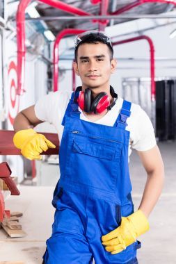 亞洲木匠用電動(dòng)鋸在車間