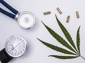 听诊器、 血压计和绿色透明胶囊中药含白色医疗表上的医疗大麻叶。在心脏病学和内科医用大麻的使用