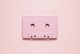 复古浪潮。粉红色的背景上画卡带的创意照片