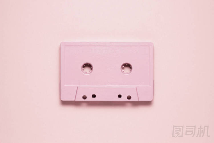复古浪潮。粉红色的背景上画卡带的创意照片