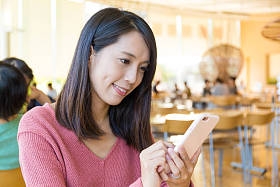在餐厅使用移动电话的女人图片