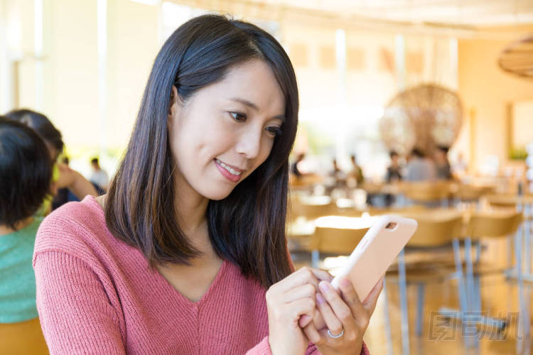在餐廳使用移動電話的女人圖片