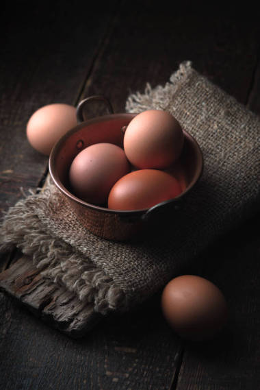 鸡蛋在库珀锅垂直木制的桌子上