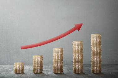 紅色箭頭圖表隨硬幣堆棧照片