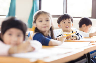 快乐的小男孩在教室里学习照片