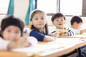 快乐的小男孩在教室里学习照片