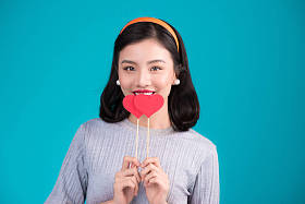 微笑亚裔女子和纸做的爱心 图片