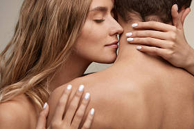 年轻漂亮的女人闻男人光滑的皮肤。热恋中的情侣