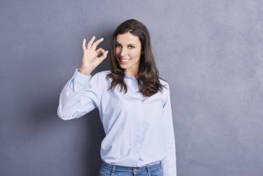 年轻女人显示 ok 的手势图片