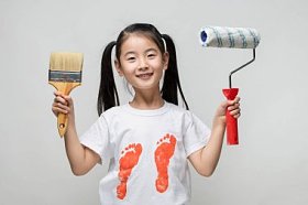 可爱的亚洲女孩抱着画笔和颜料的滚子