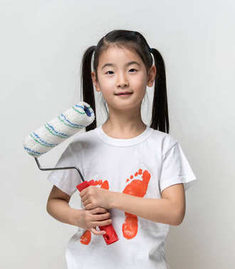 可愛的亞洲女孩抱著油漆滾筒