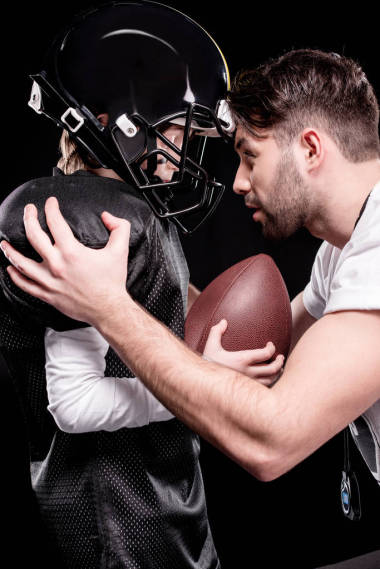 教練和踢足球的男孩圖片