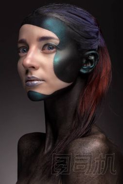 一個(gè)女人的肖像與創(chuàng)造性的化妝在灰色的背景