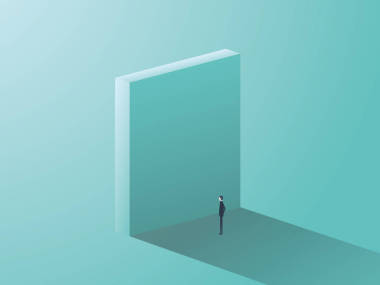 站在巨大的墻前作為象征的業(yè)務挑戰(zhàn)和克服的商人