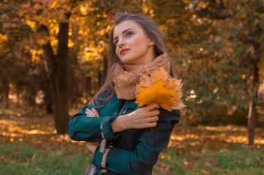 年輕漂亮的女孩站在遠(yuǎn)處的街拍上，不停樹葉