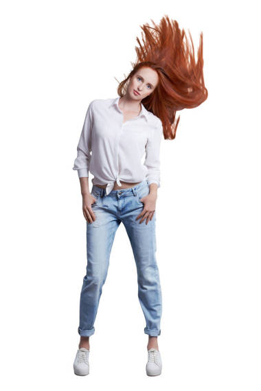 年輕漂亮的長瘦模特穿著白色襯衫和藍(lán)色牛仔褲的紅頭發(fā)