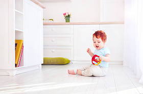 可爱的小姜宝贝男孩玩玩具在明亮的厨房里，在家