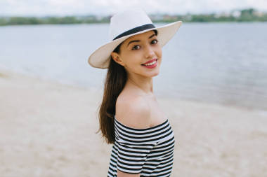 在海灘上的帽子的女人