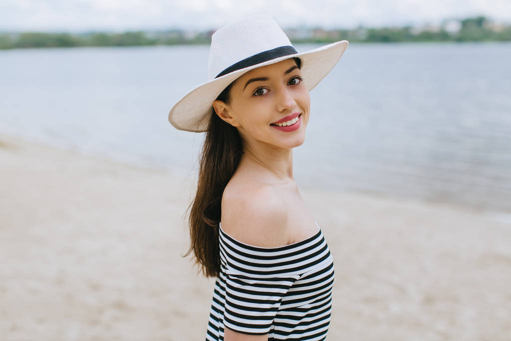 在海滩上的帽子的女人