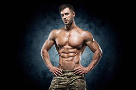 健壮的年轻人在深色背景上的工作室