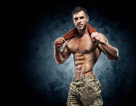 健壮的年轻人在深色背景上的工作室