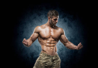 健壯的年輕人在深色背景上的工作室