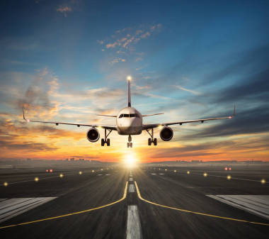 飛機(jī)降落到機(jī)場(chǎng)跑道在夕陽(yáng)光圖片
