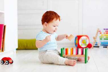 快樂的嬰兒寶貝男孩玩玩具在家