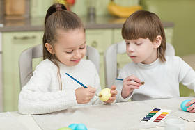 弟弟和妹妹被绘在桌上的复活节彩蛋