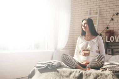 懷孕的女人在床上照片