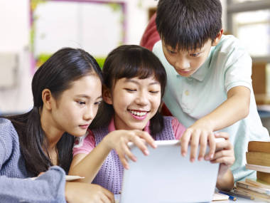 亞洲小學(xué)學(xué)生在課堂中使用平板電腦