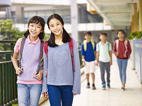 亚洲小学女孩走在走廊上