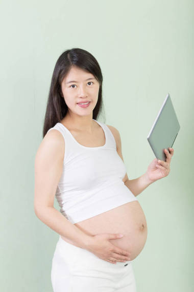 年輕漂亮的孕婦與平板電腦
