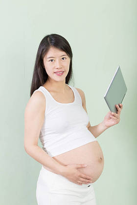 年轻漂亮的孕妇与平板电脑