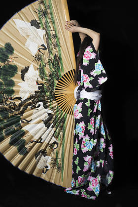 在与上的大风扇的传统日本和服的日本女孩