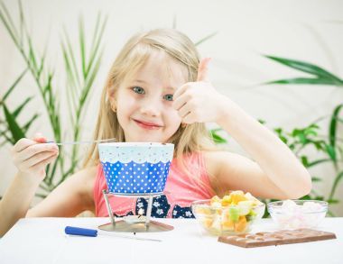 這個(gè)女孩舉起一根手指同時(shí)準(zhǔn)備巧克力火鍋